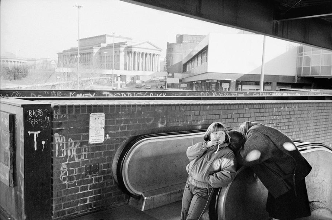 England. Merseyside. Liverpool. Children smoking with graffiti on walls.